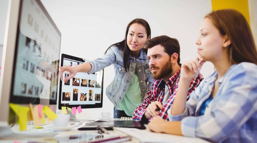 Businesswoman showing computer screen to coworkers local seo