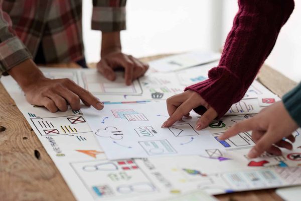 Close up ux developer and ui designer brainstorming interface wireframe design.Creative digital development agency marketing journey
