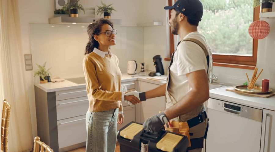 Professional repairman in uniform shaking hands with woman while standing at home kitchen AI automation services
